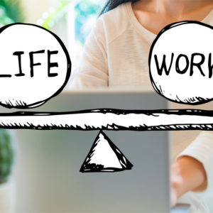 Frau am heimischen Laptop, davor gezeichnete Work-Life-Waage