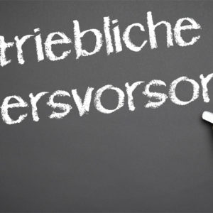 Hand schreibt "Betriebliche Altersvorsorge" auf eine Tafel