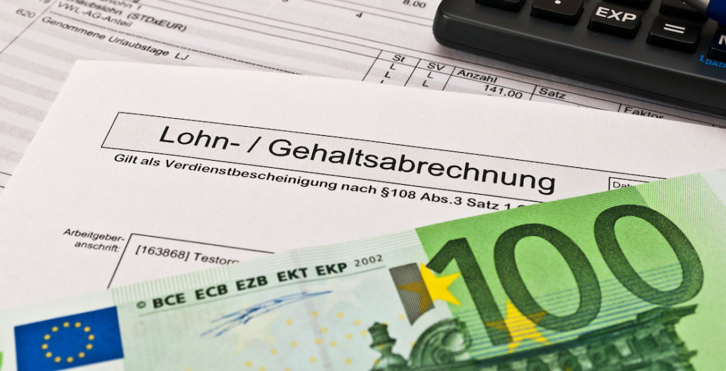 Gehaltsabrechnung und 100-Euro-Schein