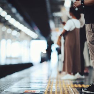 Menschen stehen an einem Bahngleis