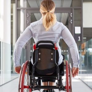 Frau im Rollstuhl in einem Bürogebäude