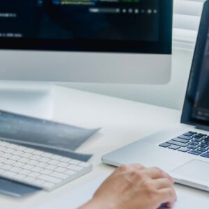 Mann arbeitet an zwei Bildschirmen