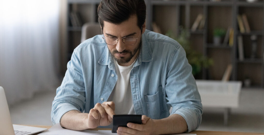 Mann mit Taschenrechner prüft seine Gehaltsabrechnung. Mann mit Taschenrechner prüft seine Gehaltsabrechnung.