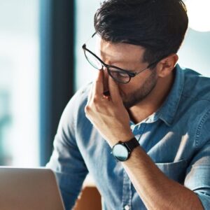 Gestresster Mann im Büro am Laptop